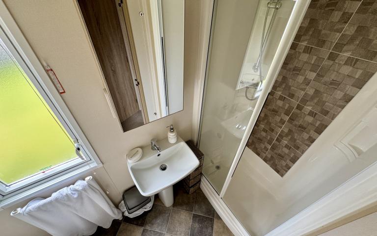 Interior of Bathroom with shower, toilet and sink.