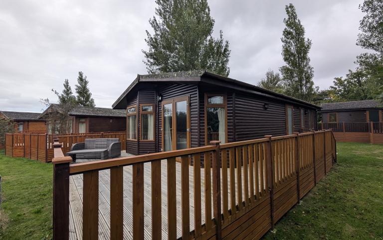 Exterior of a static caravan with a wooden decking.