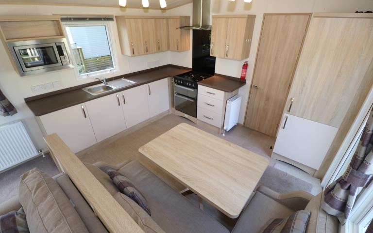 Interior view of the open plan kitchen and dining area with table.