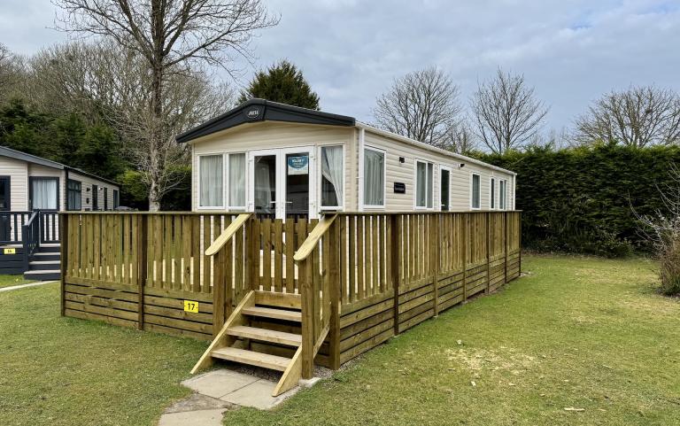 Exterior of a static caravan with a wooden decking.