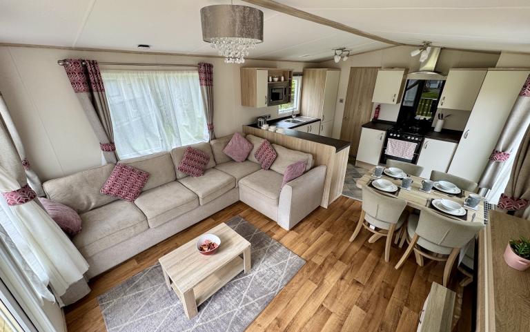 Interior view of the living room with dining space and kitchen in the background.