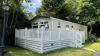 Outside View of a Caravan Holiday Home with a Decking area surrounded by Trees