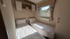 Twin bedroom with two single beds, bedside table and overbed storage. 
