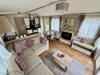 Interior view of the living room, with L shaped sofa, fireplace, TV and TV stand.