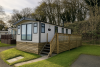 Exterior of static caravans with wooden decking. 