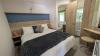 Master bedroom with double bed and a vanity table and stool. 