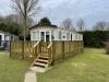 Exterior of a static caravan with a wooden decking.